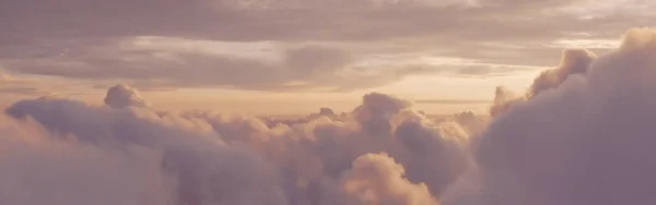 Image of large light purple clouds with clearer skies in the distance.