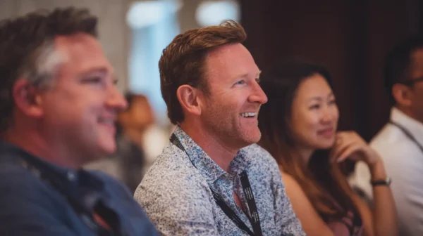 Smiling attendees engaged in a Node Talks conference session indoors