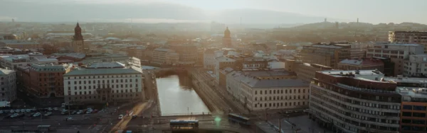 Image of Gothenburg city center at sunset showing buildings along a canal with streets, bridges, and surrounding urban skyline.