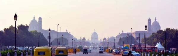 Image of the New Delhi skyline with purple tinted skies and a busy road