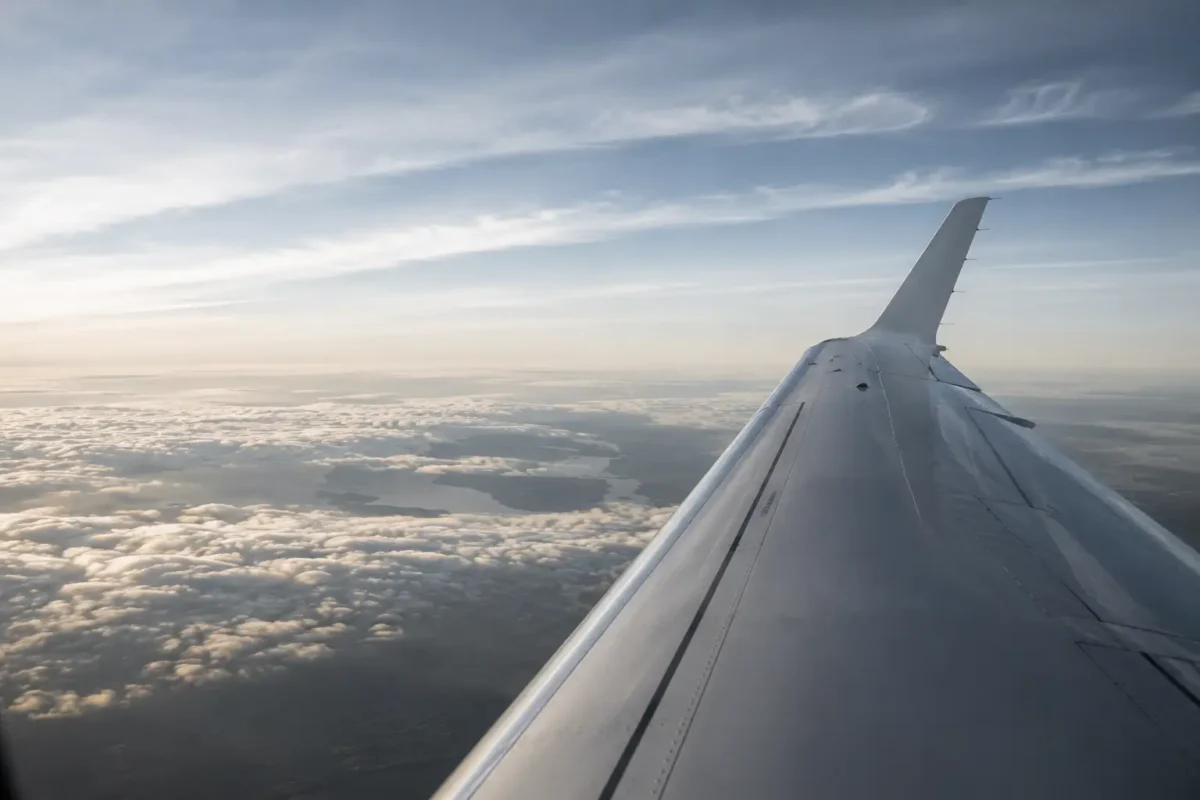 Image of an airplane wing from inside the plane.